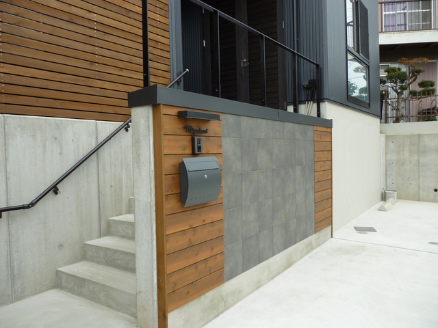 塀には木と瓦色のタイルを組み合わせ全体的にモダンなデザインで統一