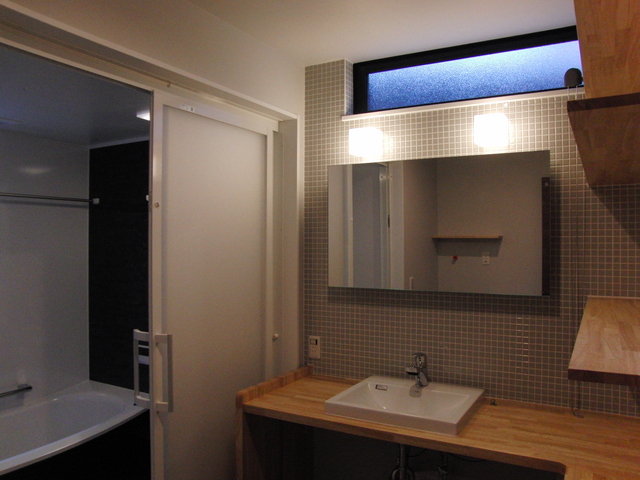 洗面室の壁はグレーを基調としたモザイクタイル　カウンターはE-HOMEオリジナル